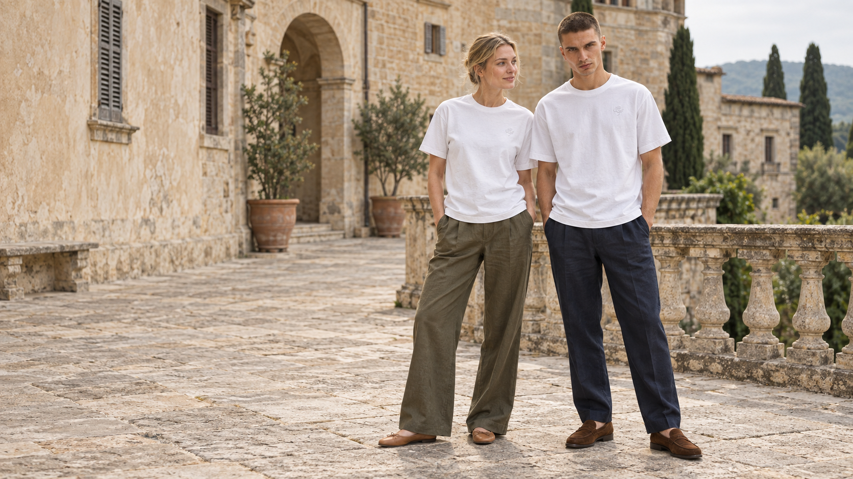 Frau und Mann in hellen CONSTANTIN T-Shirts vor einem historischen Anwesen